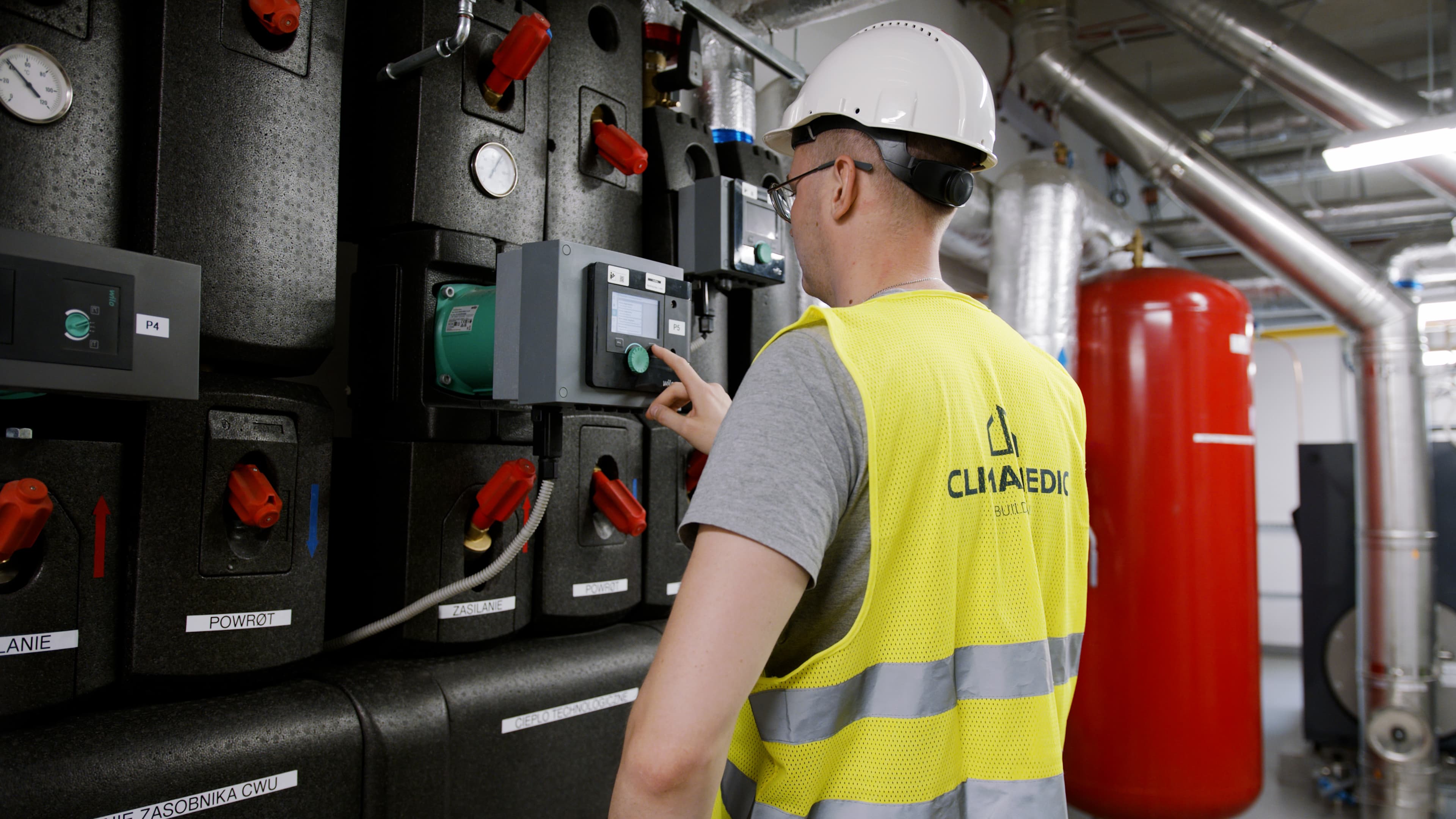 Mężczyzna w kasku w żółtej kamizelce 